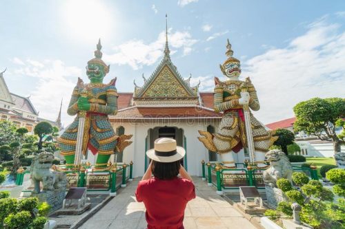 beautiful-woman-tourist-held-camera-to-capture-memories-wat-arun-temple-thailand-using-as-background-travel-concept-134780354
